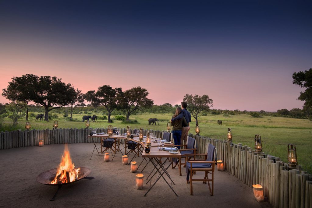 Tourist standing in boma watching elephants on African Safari trip