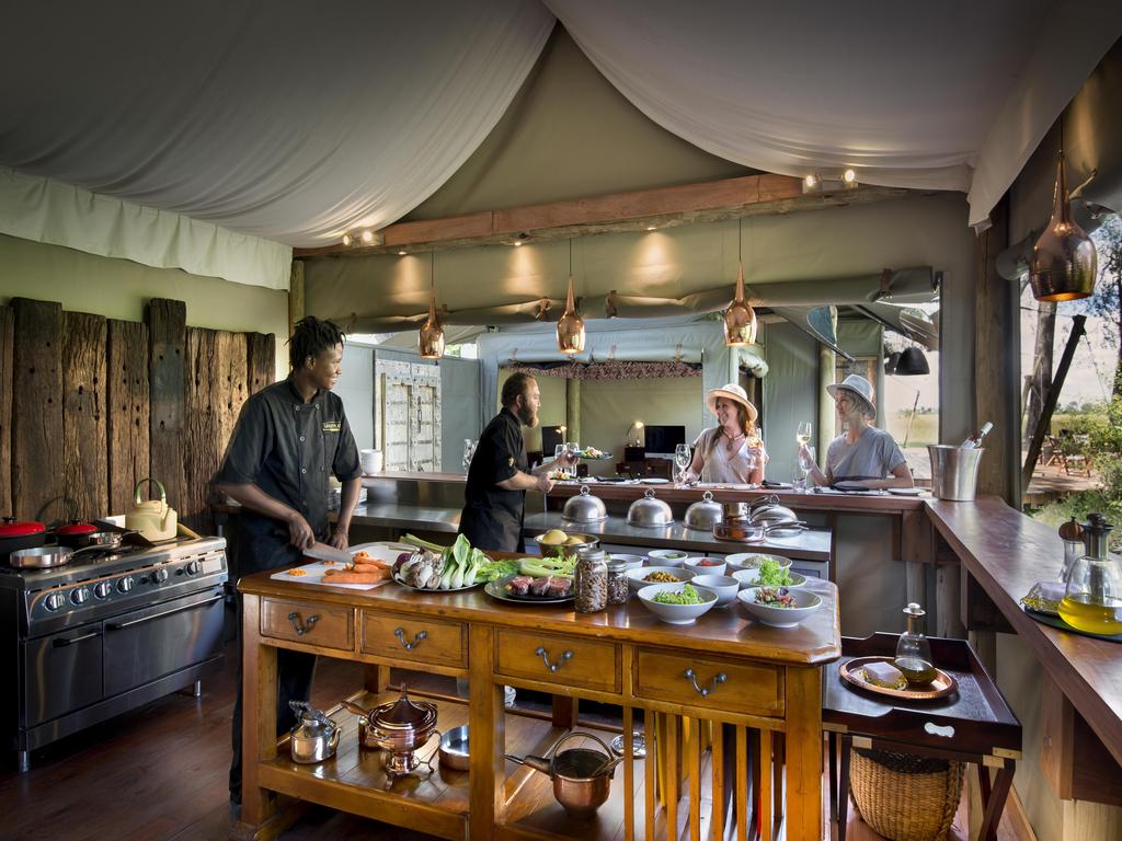 Guests at open kitchen of luxury safari camp Duba Plains