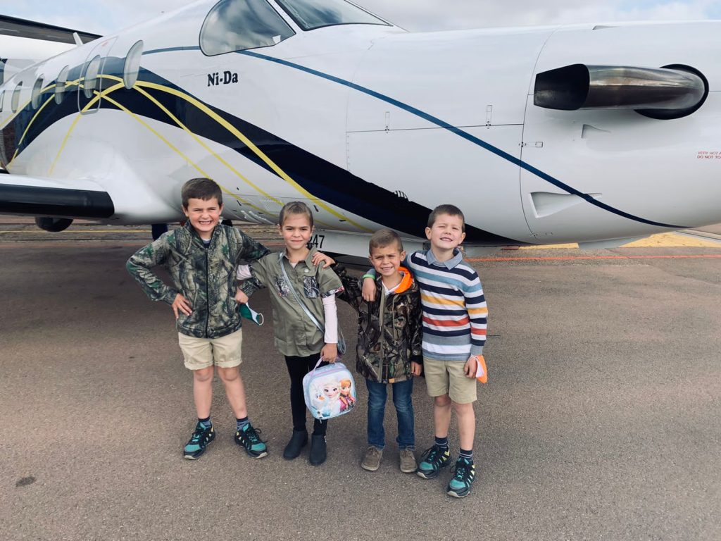four kids stands next to Pilatus PC12 ready for safari